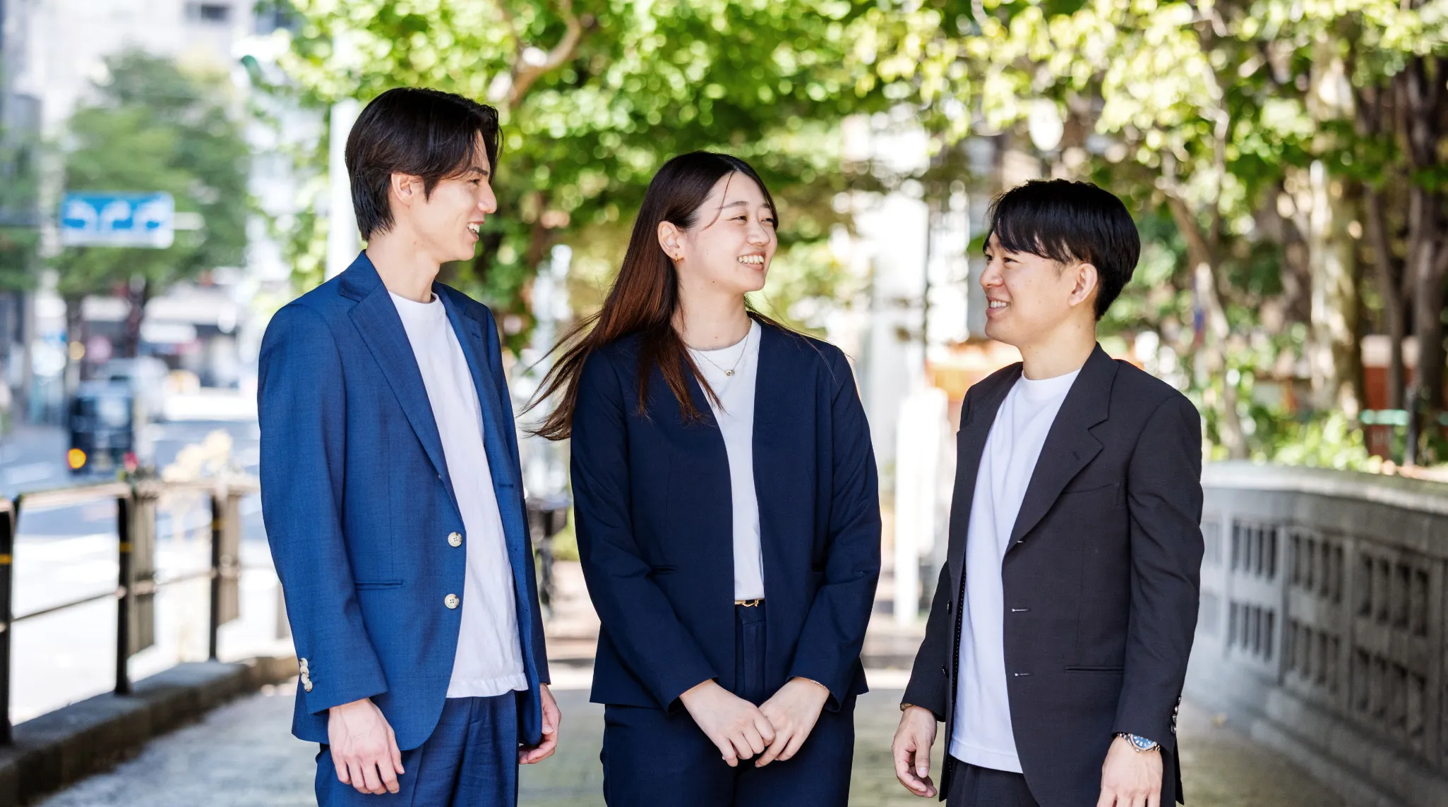 男性2人、女性1人路地の木陰でお話している様子