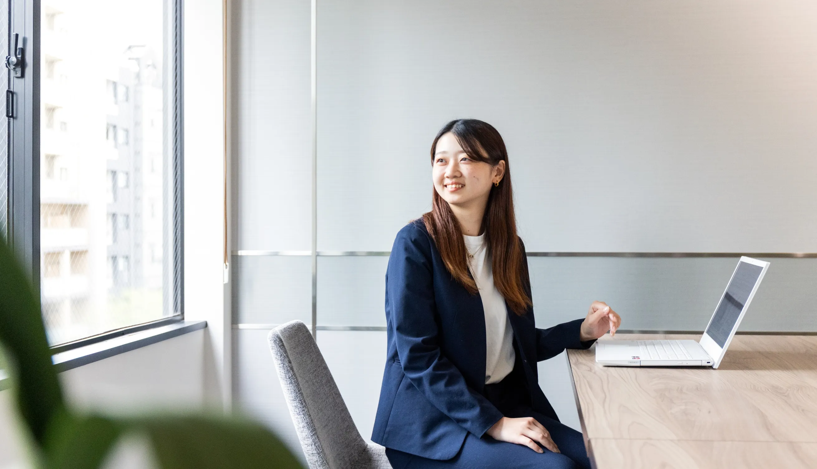 女性社員がパソコン開いて仕事をしている